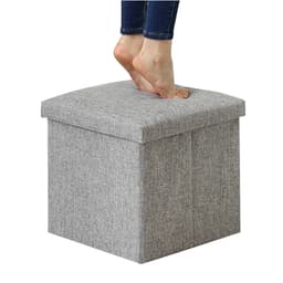 A grey foldable storage ottoman with a textured fabric, featuring a person’s bare feet on top.