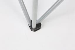 A close-up of a silver folding beach chair leg connector, featuring a black plastic base.