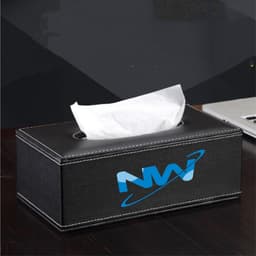 A black leather tissue box with a white tissue emerging from the top. It features a logo on one side.