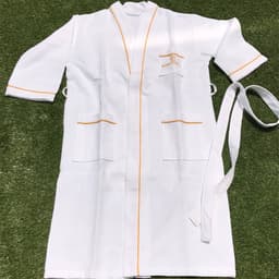 A white cotton unisex bathrobe with orange trim, featuring two front pockets and a tie belt.