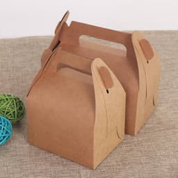 Two brown gable boxes made of kraft paper, featuring handles for easy carrying, on a textured surface.