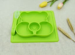 A green, bear-shaped non-slip children's plate with three compartments and a matching spoon.