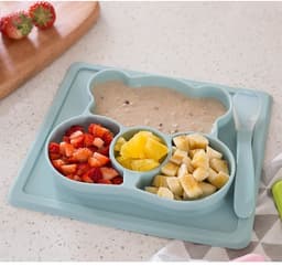 A non-slip children's plate in soft blue, featuring divided sections for food and a matching spoon.