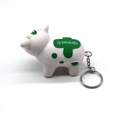 A white and green milk cow stress key chain with a keyring attached.