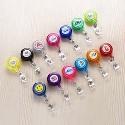 A collection of colourful retractable badge holders in various designs, including yellow, red, blue, green, and purple.