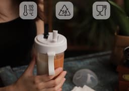 A drink bottle with a compartmentalised design, featuring a double straw and a white lid. It has a logo.