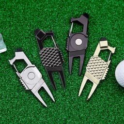 A collection of four 7-in-1 golf tools in silver, black, and gold, displayed on green turf with a golf ball nearby.