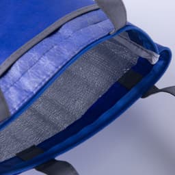 A blue lunch cooler tote with an insulated silver interior and grey handles, featuring a zip closure.