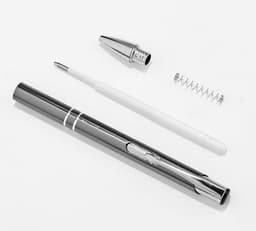 A metal ballpoint pen in silver, with its cap, nib, and inner spring laid out separately.