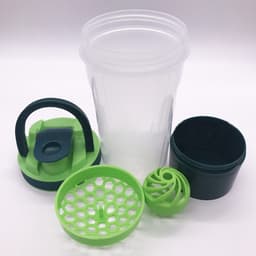 A drink bottle with a transparent body, green lid, and accessories including a storage container and mixing ball.
