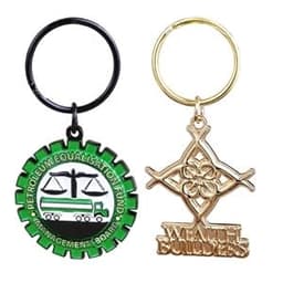 A soft enamel keychain featuring a green circular design with a black outline and a gold geometric design on a keyring.