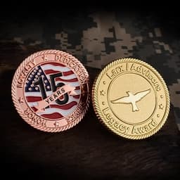 A die struck challenge coin featuring a bronze side with a flag design and a gold side with an eagle emblem and text.