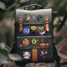 A dark green backpack adorned with colourful enamel lapel pins, featuring various character designs and logos.