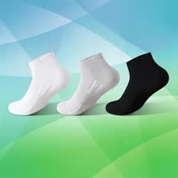 Three pairs of low cut cushioned sports socks in white and black against a colourful background.