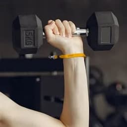 A hand holding a black dumbbell with an orange silkscreen lobster clasp wristband on the wrist.
