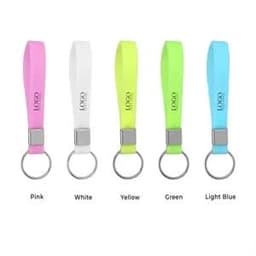 Five silicone wristbands in pink, white, yellow, green, and light blue attached to key rings. Each has a logo.
