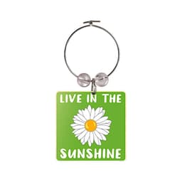 A drink bottle charm with a green background, a daisy illustration, and text reading "Live in the Sunshine."
