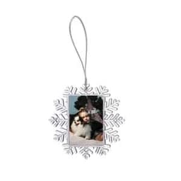 A large, silver snowflake-shaped photo frame displaying a picture of a girl with a dog, complete with a hanging loop.