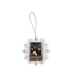 A small, silver snowflake-shaped photo frame featuring a wooden door design, attached with a hanging string.
