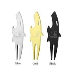 A divot tool in shark shape, featuring silver, gold, and black colours. It has a logo on the design.