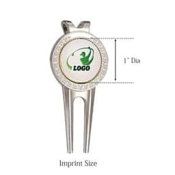 A silver golf divot tool featuring a round ball marker, with a logo in the centre and measuring 1 inch in diameter.