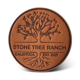 A brown leather patch featuring a tree design with the text "Stone Tree Ranch" and "Calistoga Est. 2021".