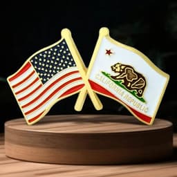 A lapel pin featuring crossed flags of the USA and California, in red, white, blue, and gold.