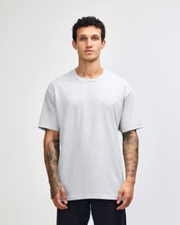 A lightweight grey unisex t-shirt is displayed on a model, featuring a relaxed fit and plain design.