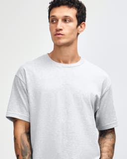 A grey heavyweight cotton unisex t-shirt displayed on a model, featuring short sleeves and a crew neckline.