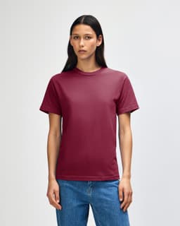 A maroon heavyweight cotton unisex T-shirt displayed on a male model, featuring a minimalistic design and a logo.