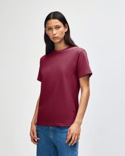 A maroon heavyweight cotton unisex T-shirt displayed on a model, featuring a logo on the collar.