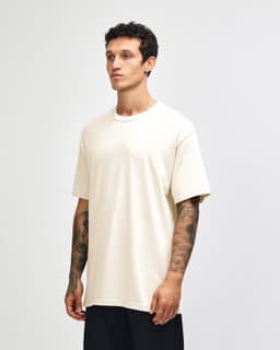 A heavyweight cotton unisex t-shirt in cream, displayed on a model with a neutral background.