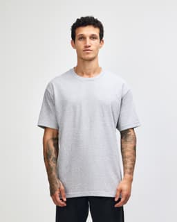 A heavyweight cotton unisex T-shirt in grey, featuring short sleeves and a relaxed fit. It has a logo on it.