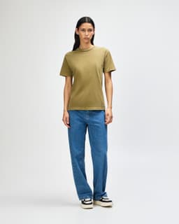 A unisex heavyweight cotton T-shirt in olive green, paired with light blue cargo pants. A logo is present.