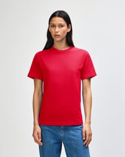 A red heavyweight cotton unisex t-shirt displayed on a model with curly hair, featuring a simple design.