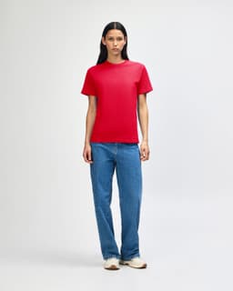A red heavyweight cotton unisex T-shirt displayed on a model, paired with blue cargo pants.