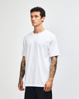 A heavyweight cotton unisex T-shirt in light grey, displayed on a male model. The shirt features a logo.