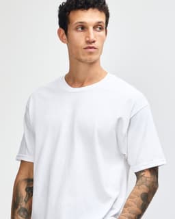 A heavyweight unisex t-shirt in light grey, featuring a classic crew neckline and short sleeves. It has a logo on it.