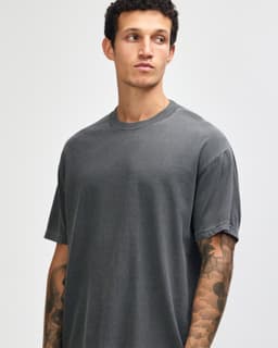 A grey unisex garment-dyed heavyweight cotton T-shirt with a relaxed fit and short sleeves, featuring a logo.