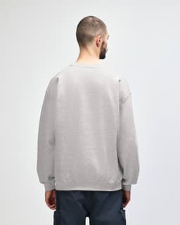 A grey Gildan Heavy Blend adult crewneck sweatshirt viewed from the back, featuring a simple design and a branding logo.