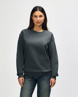A grey Gildan Heavy Blend adult crewneck sweatshirt displayed on a model, featuring long sleeves and a relaxed fit.