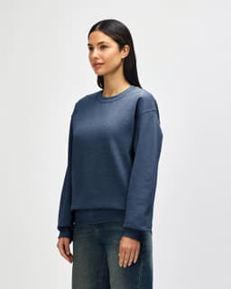 A blue Gildan Heavy Blend adult crewneck sweatshirt with long sleeves, featuring a logo on the front.