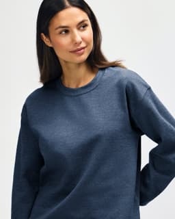 A blue Gildan Heavy Blend Adult Crewneck Sweatshirt on a model, featuring a casual fit and long sleeves.
