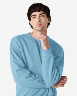 A blue Gildan Heavy Blend adult crewneck sweatshirt worn by a model, featuring a casual pose and long sleeves.