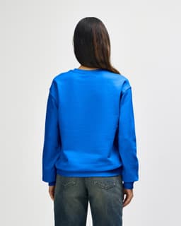 A blue Gildan Heavy Blend adult crewneck sweatshirt, view from the back, with a relaxed fit and long sleeves.