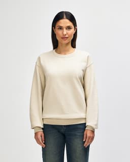 A beige Gildan Heavy Blend adult crewneck sweatshirt displayed on a model, featuring a relaxed fit and long sleeves.