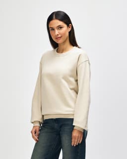 A beige Gildan Heavy Blend adult crewneck sweatshirt displayed on a model, with a plain design and relaxed fit.