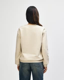 A cream-coloured Gildan Heavy Blend adult crewneck sweatshirt, featuring a logo, displayed from the back.