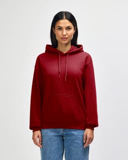 A red hooded sweatshirt with a front pocket and drawstring hood. The model is posed against a plain backdrop.