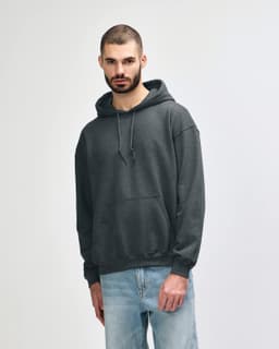 A grey Gildan Heavy Blend adult hooded sweatshirt displayed on a model, featuring a front pocket and a hood.